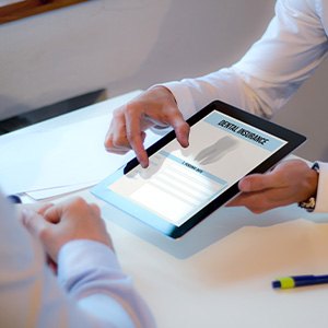 Two people looking at dental insurance on a tablet