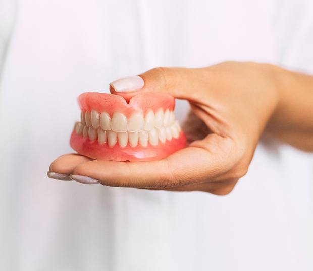 Dentist holding full dentures