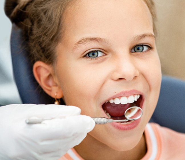 Young girl in the dentist’s chair undergoing a checkup 